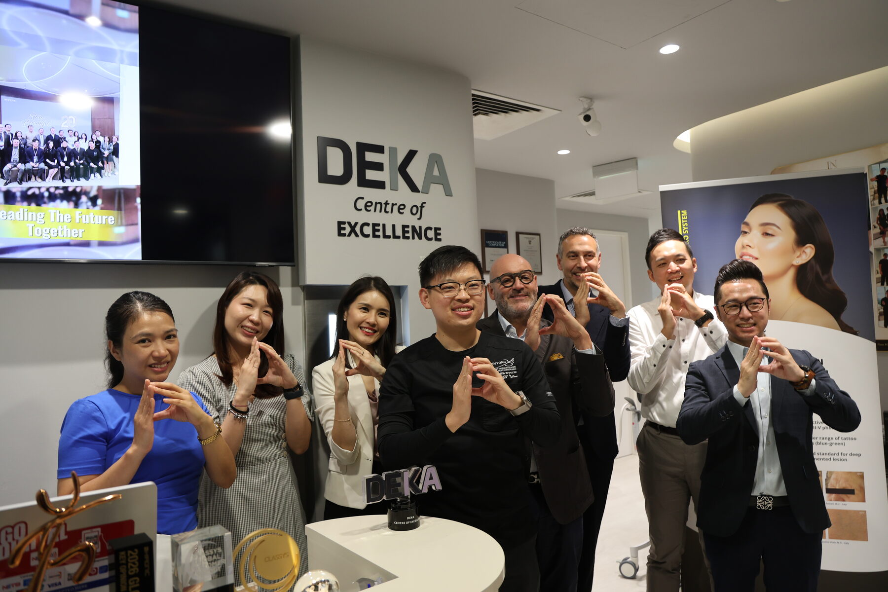 Dr Sin Yong with the visiting DEKA delegation beneath the DEKA Centre of Excellence signage at IN Eternity Clinic, Orchard Road, Singapore