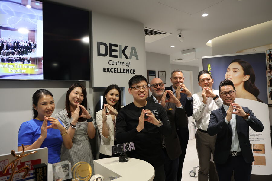 Dr Sin Yong and the DEKA delegation beneath the DEKA Centre of Excellence signage, Singapore